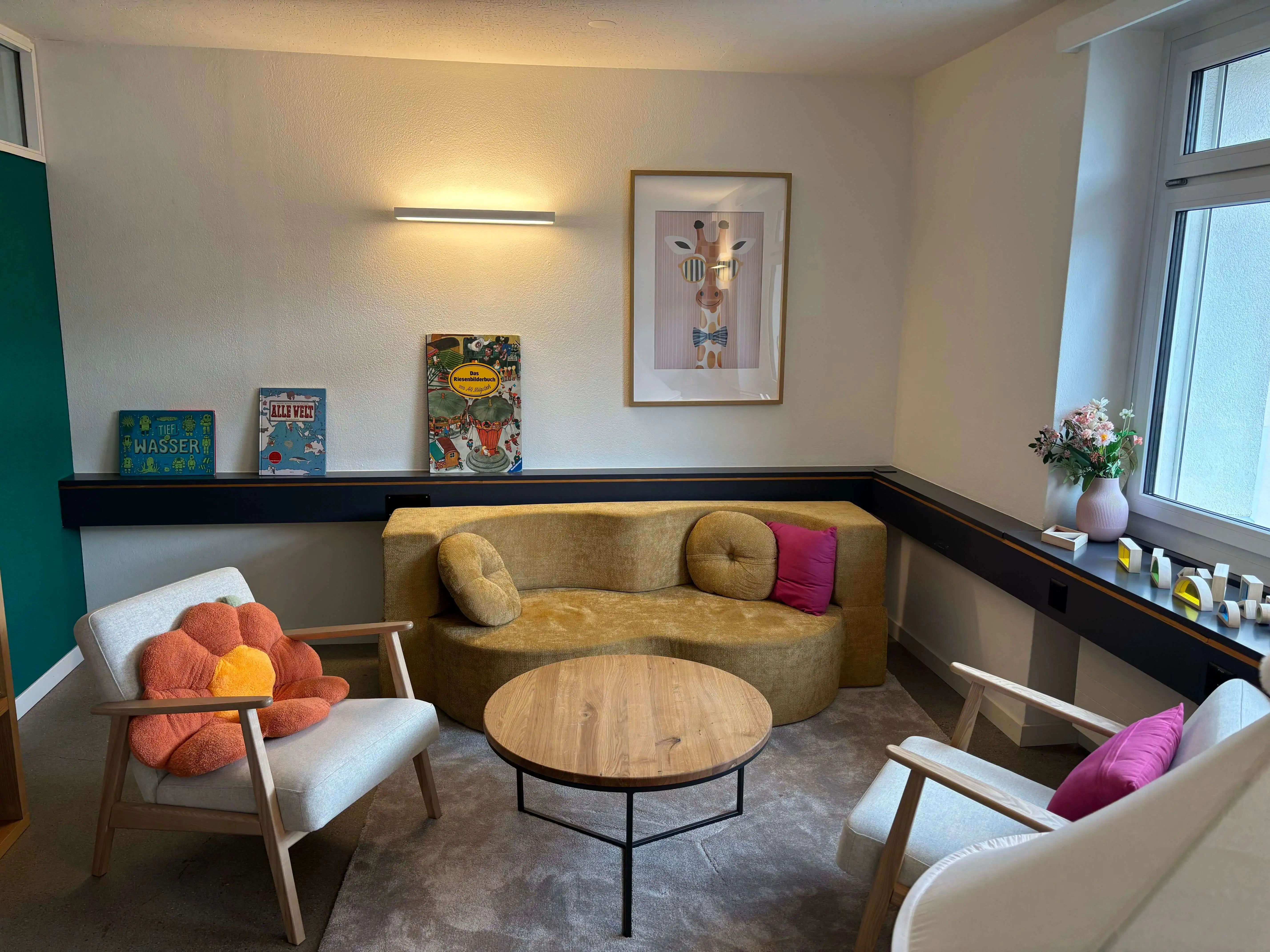 Sitzbereich im Cocon-Besuchsbegleitungszimmer mit Sofa, Sesseln und Spieltisch
